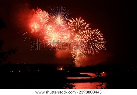 Beautiful red and gold fireworks light up the sky for Canada Day on a summer night by the lake in Toronto, Ontario, Canada.