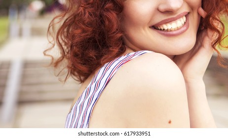 Beautiful Red Haired Woman With Fresh Flawless Skin And Curly Hairstyle In Dress, Smiling Cheerfully In Park. Ideal Teeth. Sunny Day. Close Up Of A Smile