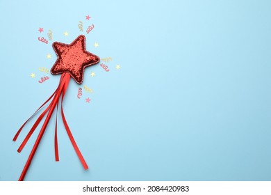 Beautiful Red Magic Wand And Confetti On Light Blue Background, Flat Lay. Space For Text