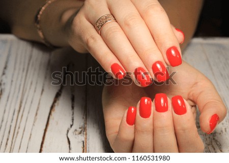 beautiful red manicure of nails on the background of fashionable texture