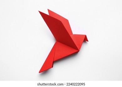 Beautiful red origami bird on white background, top view
