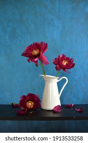 Beautiful red peony flowers in white pitcher jug