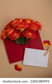 Beautiful Red Roses Flowers In Postal Red Envelope On Neutral Beige Background, Empty Paper Note Copy Space For Text, Spring Time, Greeting Card For Holiday. Flower Delivery. Delicate Red Yellow Roses