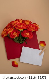 Beautiful Red Roses Flowers In Postal Red Envelope On Neutral Beige Background, Empty Paper Note Copy Space For Text, Spring Time, Greeting Card For Holiday. Flower Delivery. Delicate Red Yellow Roses