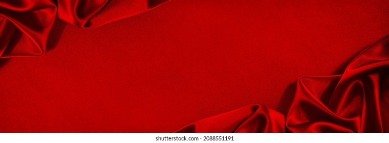 Beautiful Red Silk Satin Background. Soft Folds On Shiny Fabric. Luxury Background With Copy Space For Text, Design. Wide Banner. Flat Lay, Top View. Birthday, Christmas, Valentine.