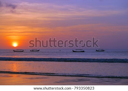 Beautiful red sun sunset with fisherman's boats silhouettes, Kuta beach, Bali