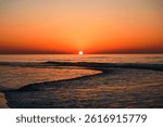 A beautiful red sunset over Lake Erie with calm waves