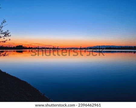Beautiful red sunset over lake Cice, Turopolje, near Velika Gorica in Croatia. Calm, clean water. Copy space 