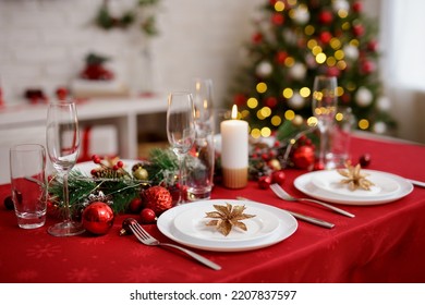 Beautiful red table with plates and champagne glasses for family christmas dinner - Powered by Shutterstock