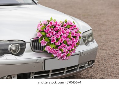Beautiful red wedding bouquet on the car.