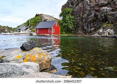 Beautiful Red Wooden Hut On The Shore Of A Fjord In The Nordic Sea Of Norway, Near Bergen