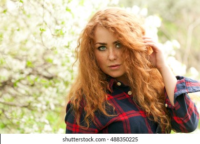 Beautiful Red-haired Woman With Freckles And Spring Cherry Blossoms