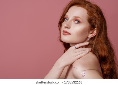 Beautiful Redhead Freckled Woman With Bold Pink Eyes Makeup, Wearing Stylish Jewelry: Earrings, Rings, Necklace, Posing In Studio. Jewellery Advertising Conception. Copy, Empty Space For Text