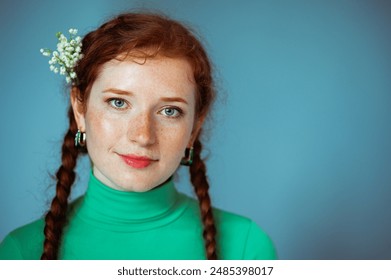 Beautiful redhead freckled woman wearing green turtleneck with bouquet of lily of the valley flowers, posing on blue background. Close up studio portrait. Copy, empty, blank space for text
 - Powered by Shutterstock