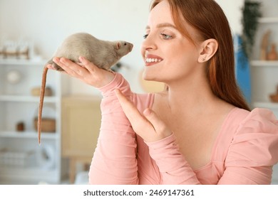 Beautiful redhead woman with cute rat at home, closeup - Powered by Shutterstock