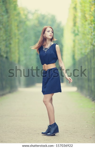 Beautiful redhead\
women in versailles\
gardens