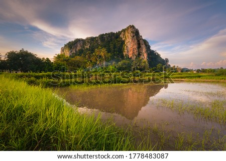 beautiful reflection of the famed historical Keriang Hill with paddy rice field on foreground minutes before sunset. Keriang Hill is located near Alor Setar, the capitalcity of Kedah.