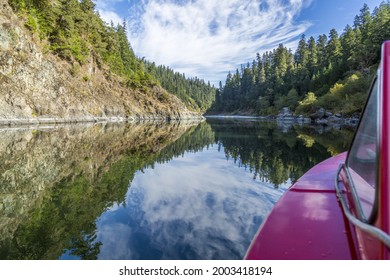 Beautiful reflection as seen from our boat on the Rogue River, Oregon, USA - Shutterstock ID 2003418194