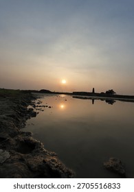 A beautiful reflection of the setting sun on a still body of water