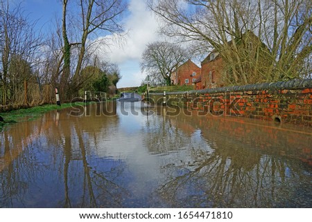Beautiful reflections of the flooded Forge Lane from the River leadon, Forge End, Highleadon, near Newent, Gloucestershire, UK