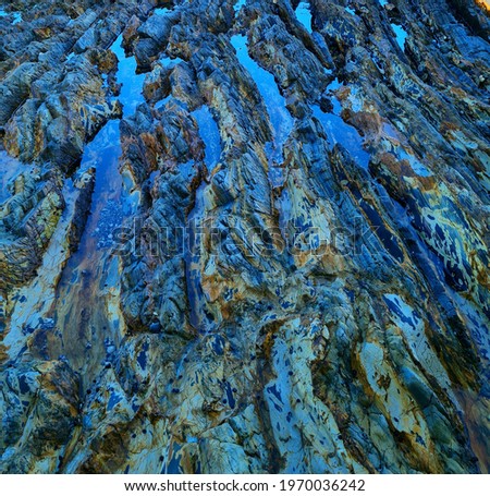 beautiful reflective rockpools in patterned rock