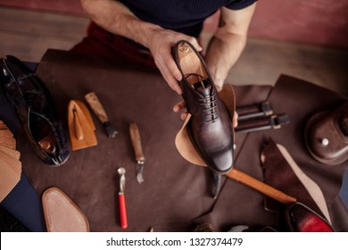 beautiful repaired shoes in man's hands. close up top view photo - Powered by Shutterstock