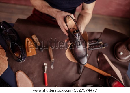 beautiful repaired shoes in man's hands. close up top view photo