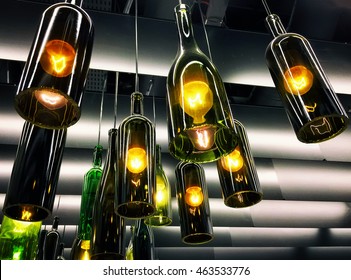 Beautiful retro light lamp decoration made of empty wine bottles. Toned