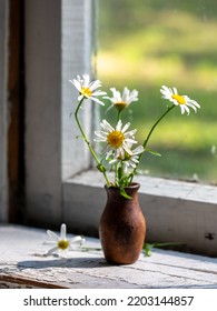 Beautiful Retro Still Life With Chamomile Flowers In Clay Jug On Windowsill Of Old Window Of Country House, Summer Cottage. Close Up, Copy Space. Floral Home Decoration. Country Life Concept Vertical