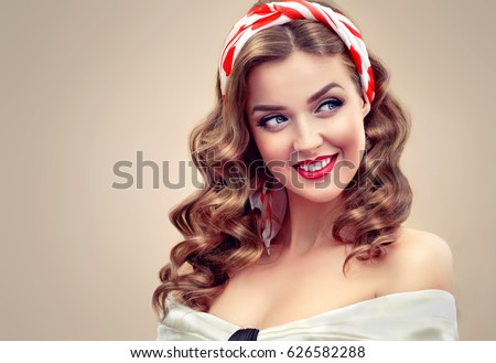 Beautiful retro vintage pin-up girl . Beautiful girl  with curly hair  pointing to the side . Presenting your product. Expressive facial expressions