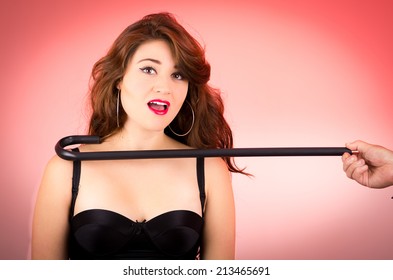 Beautiful Retro Young Girl In Sexy Being Pulled Out By A Cane Over Red Background