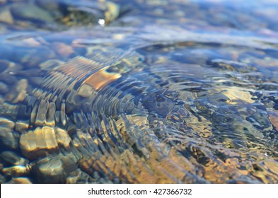 beautiful ripples on river flow over colorful stones in summer sunshine - Shutterstock ID 427366732