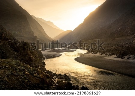 Beautiful river landscape with high mountains peaks on sunrise. Pakistan.