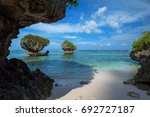 Beautiful rock formations along the sandy beach of Tanguisson Beach on the tropical island of Guam during the morning calm of the ocean on a clear, sunny day