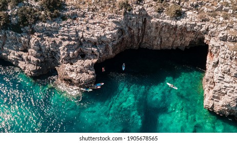 Beautiful Rocky Beach With SUP Stand Up Paddle Boards And With Turquoise Water In Montenegro. View From Above With Drone