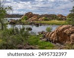 Beautiful rocky landscape at Watson Lake in Prescott, Arizona with calm water, lush greenery, and a clear sky on a tranquil day. Perfect for nature and outdoor enthusiasts.