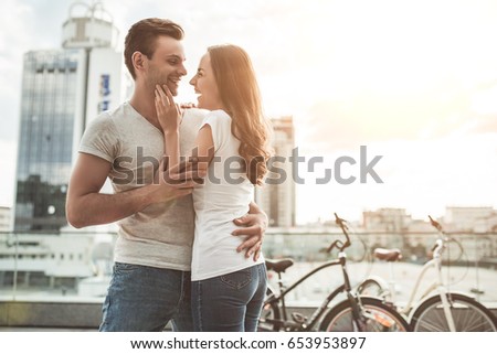 Beautiful romantic couple is having rest in the city with bicycles. Enjoying the company of each other.
