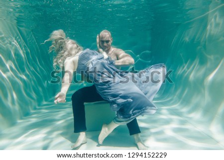 beautiful romantic couple of lovers hugging gently under water