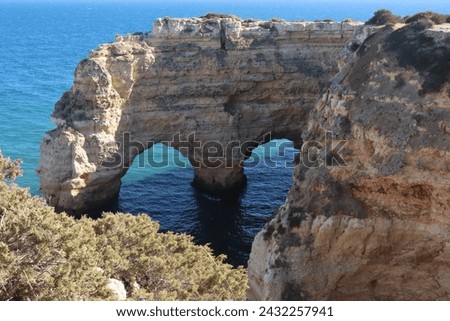 Beautiful romantic natural blue heart shape, symbol of love, in arch rocks at beach of Praia da Marinha next to portuguese Atlantic ocean sea coast near Albufeira at scenic Algarve, Portugal, Europe.