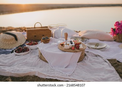 Beautiful romantic summer picnic with fresh cheese and berries on the beach at sunset. - Powered by Shutterstock