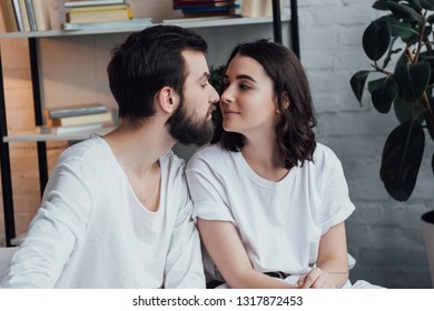 beautiful romantic young couple looking at each other in bed at home - Shutterstock ID 1317872453