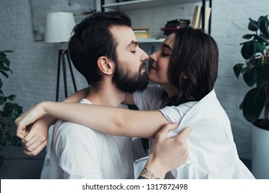 beautiful romantic young couple looking at each other and hugging at home - Shutterstock ID 1317872498