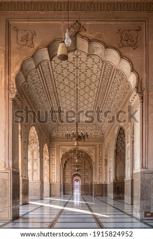 Beautiful row of aligned arches behind the facade of ancient Badshahi mosque built by mughal emperor Aurangzeb a landmark of Lahore, Punjab, Pakistan
