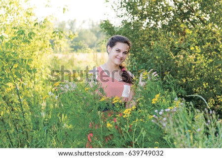 Beautiful Russian girl in thickets of tansy