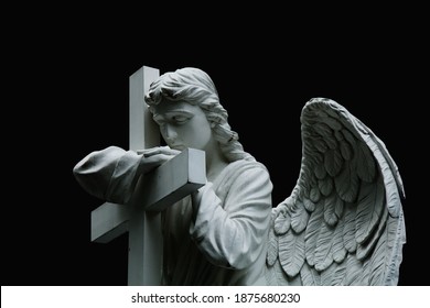 Beautiful Sad Angel With Cross. Fragment Of Ancient Stone Statue With A Sweet Expression That Looks Down As Symbol Of Unspeakable Sadness And Death. 