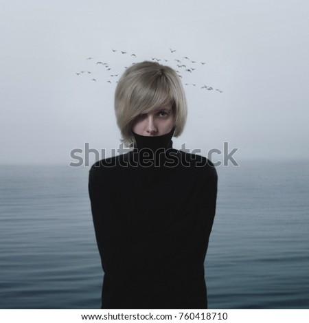 Beautiful sad blonde woman on seascape background with birds