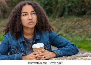 Beautiful Sad Depressed Or Thoughtful Mixed Race Biracial African American Teen Girl Teenager Female Young Woman Drinking Takeout Coffee Outside Resting On A Wall