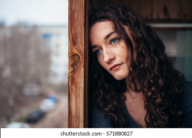 beautiful sad lonely girl sitting near the window is missing
