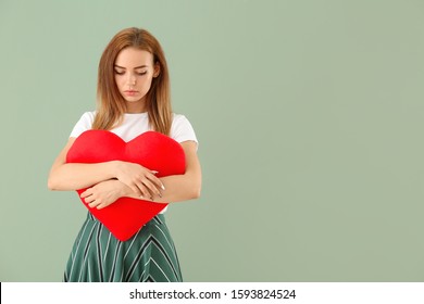 Beautiful Sad Young Woman With Big Red Heart On Color Background