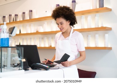 A Beautiful Saleswoman In An Ice Cream Parlor Writes Down An Order.